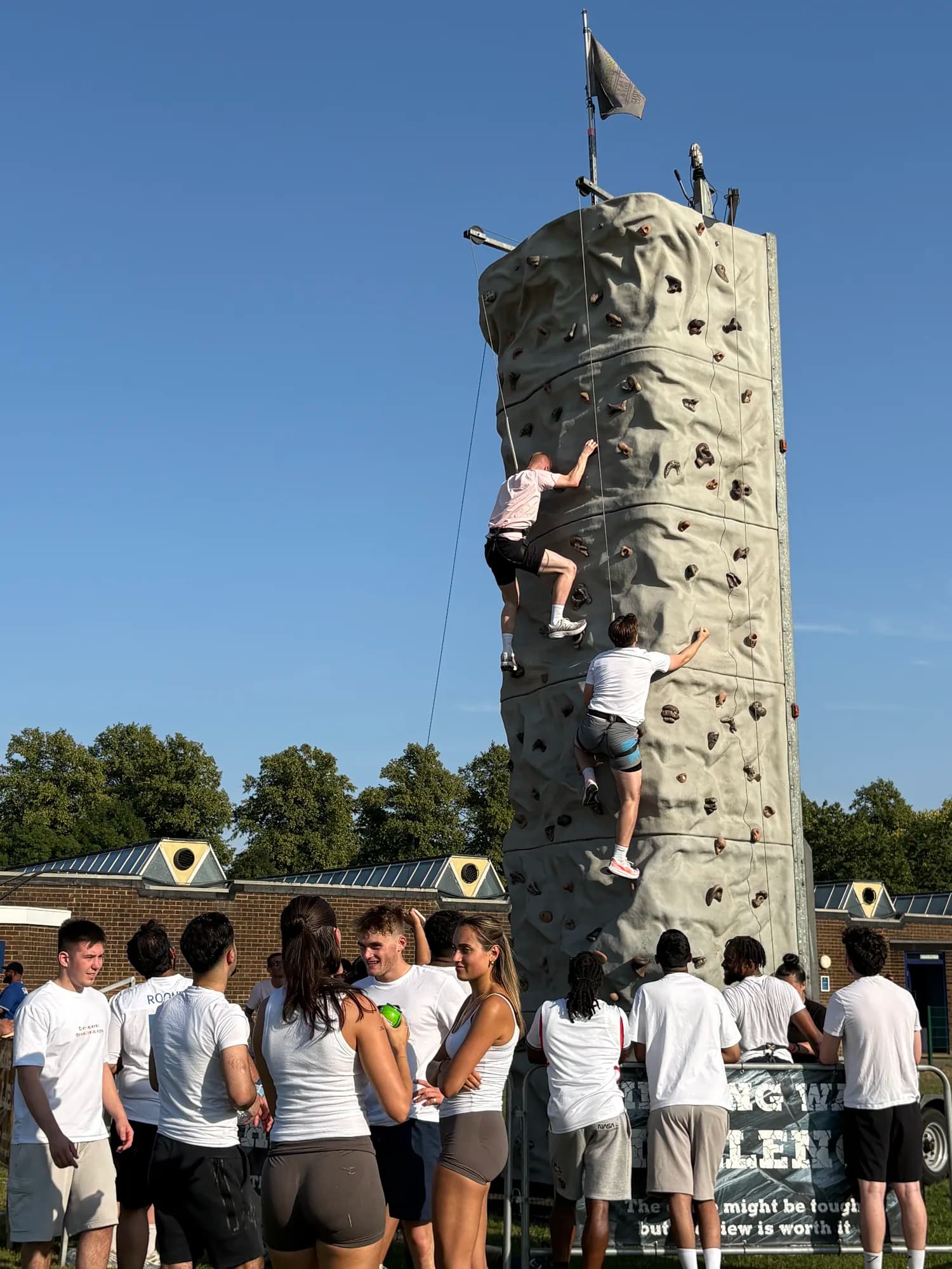 Colleagues cheering a climber up the climbing wall